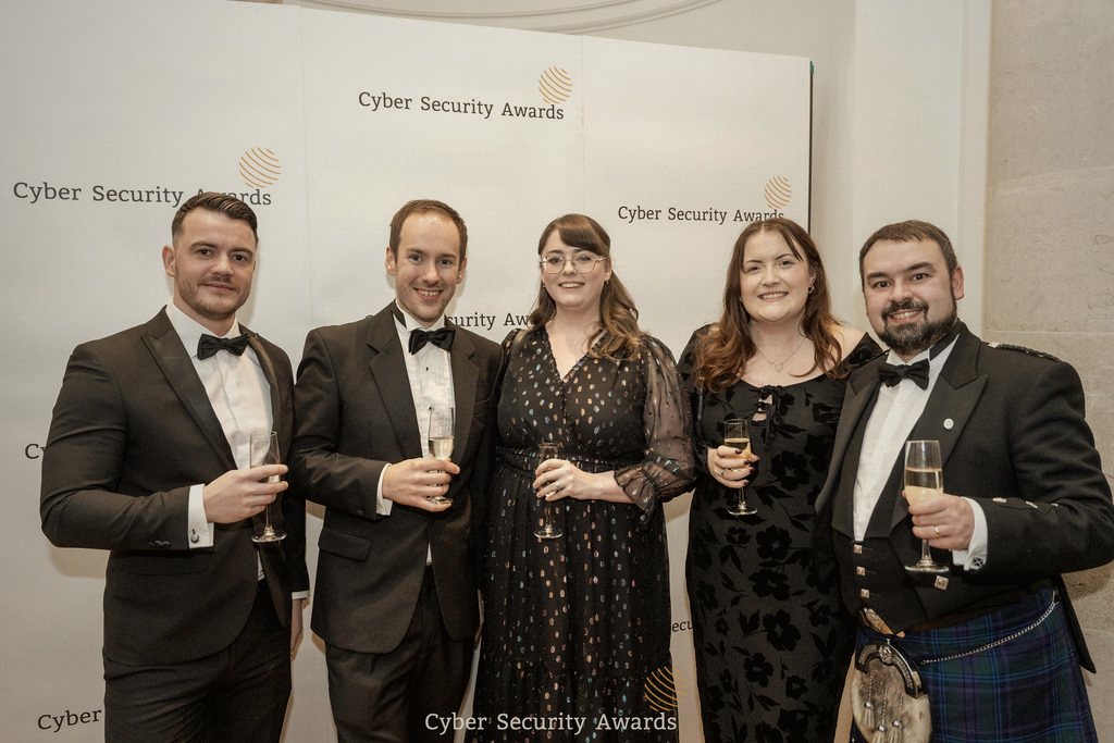 Winners in black tie gathered in front of the Cyber Security Awards backdrop at the ceremony